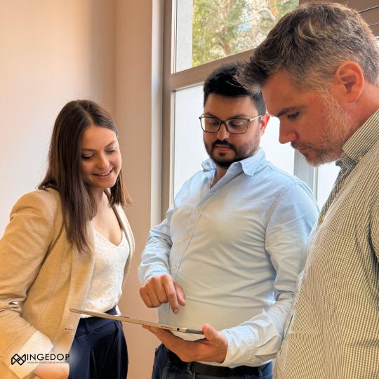 Consultores de Ingedop revisando información estratégica en una tablet durante una reunión.