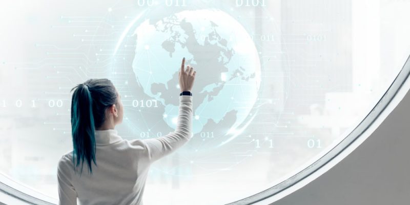 Mujer interactuando con proyección digital del planeta en concepto de transformación digital 360.
